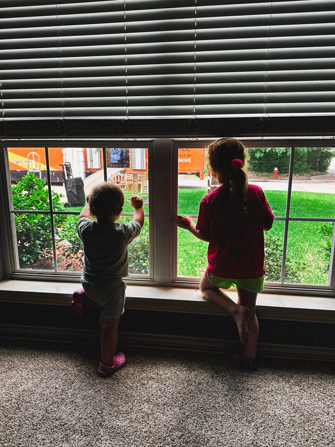 photo of Ellie and Emmie waving to the moving truck from our empty first home